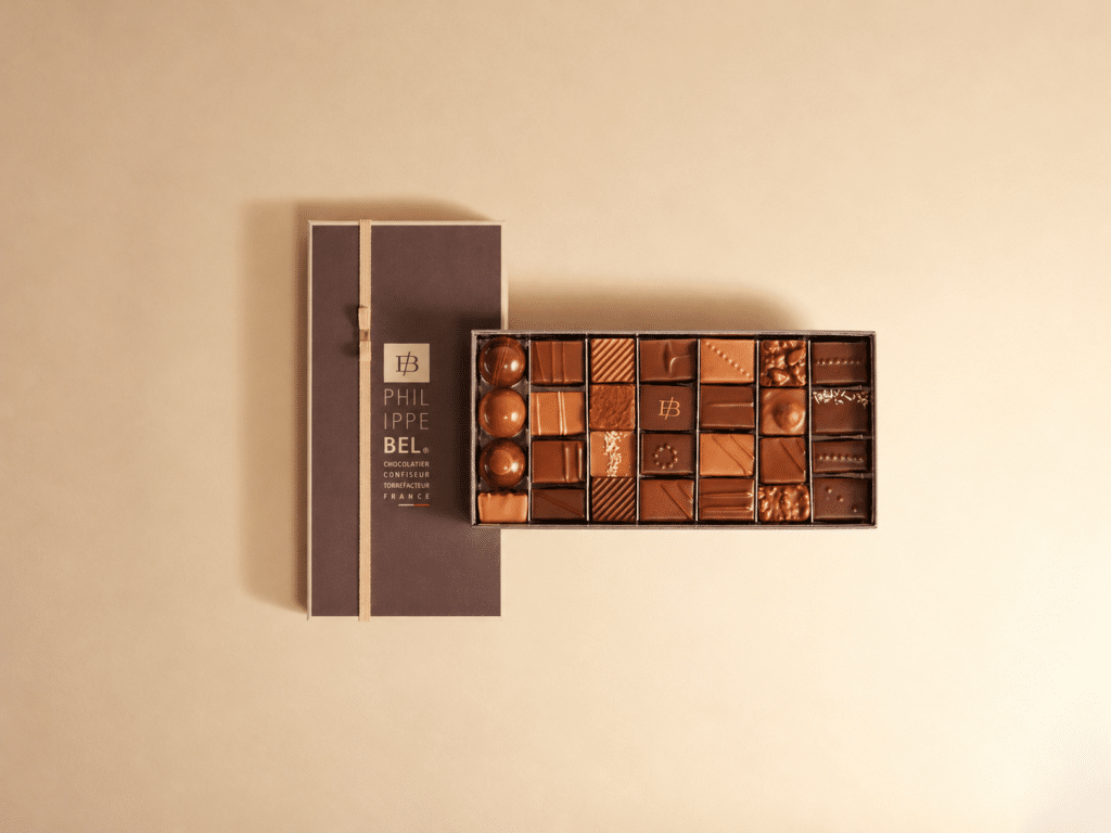 Boîte d'assortiment d'environ 28 bonbons de chocolats noirs et au lait. Ganaches, pralinés et boules de caramel semi-liquides aux pulpes de fruits. Sans alcool - 250g