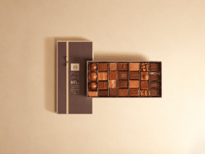 Boîte d'assortiment d'environ 28 bonbons de chocolats noirs et au lait. Ganaches, pralinés et boules de caramel semi-liquides aux pulpes de fruits. Sans alcool - 250g