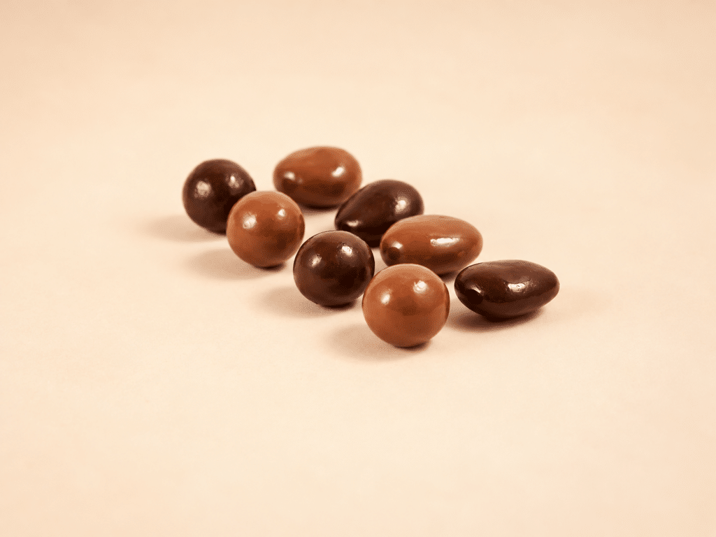 Amandes et noisettes caramélisées, enrobées de chocolat noir et lait.